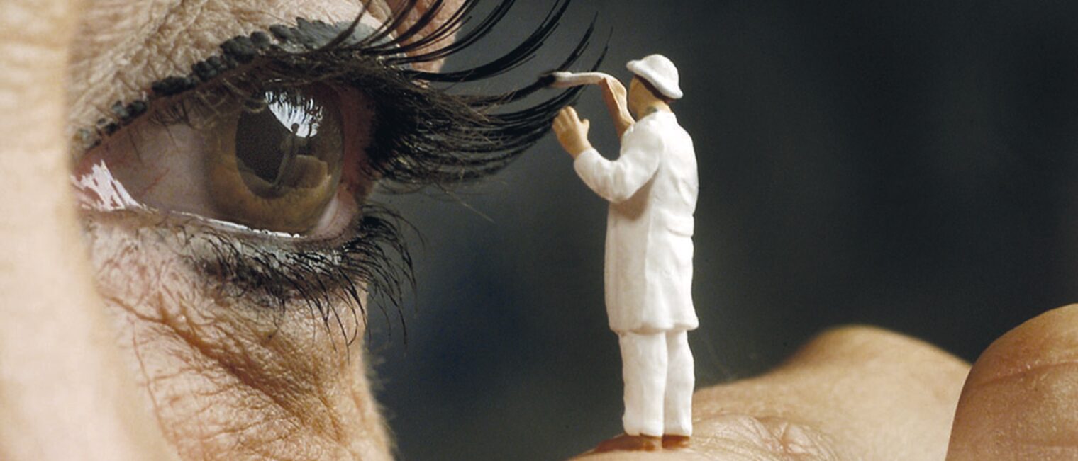 Der Restaurator malt mit dem Pinsel die Wimpern schwarz an Der Restaurator malt mit dem Pinsel die Wimpern schwarz an