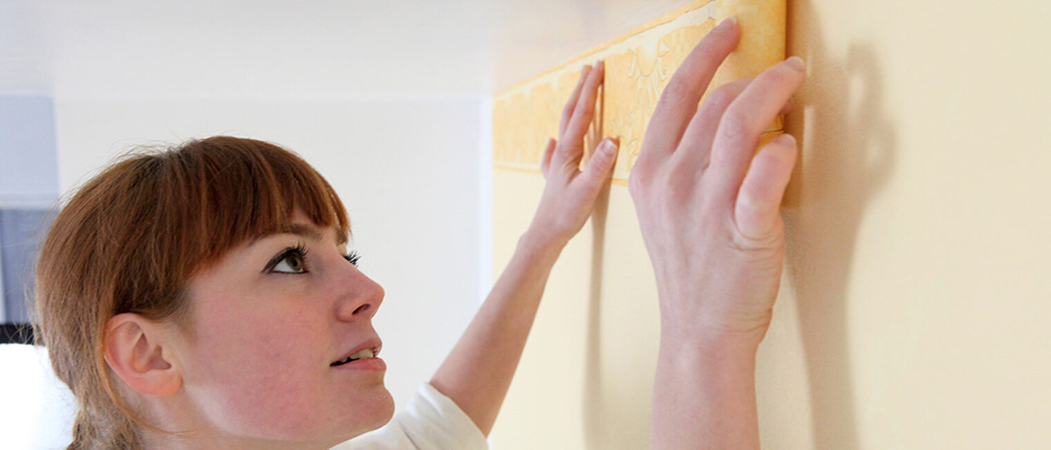 Malerin bei der Arbeit an der Wand